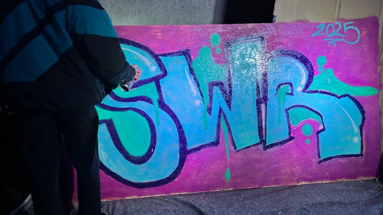 Ein SWR-Graffiti prankt an einer Wand.