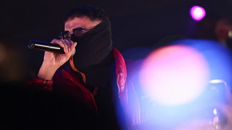 Der Rapper Haftbefehl tritt im La Louve in Gießen auf. Der Landesjungebeirat Baden-Württemberg will seine Texte auf den Lehrplan bringen.