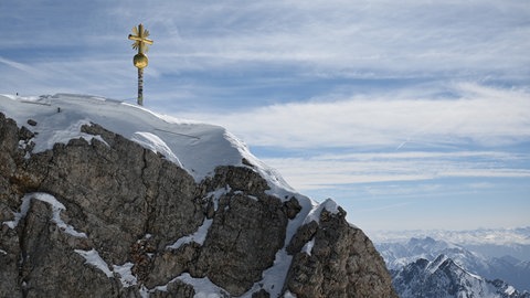 Das Gipfelkreuz der Zugspitze ist zu sehen. Bei einem Lawinen-Abgang ist am Samstag an der Zugspitze ein 19-jähriger Mann aus Baden-Württemberg ums Leben gekommen.