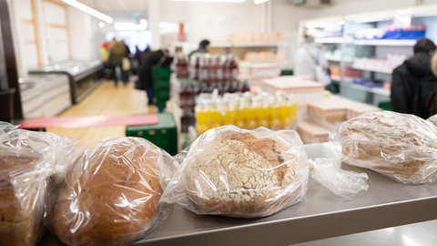 Menschen kaufen in einem Tafelladen in Stuttgart Lebensmittel.