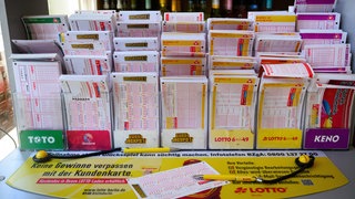 Symbolbild: Verschiedene Lotto-Scheine auf einem Kiosk-Tisch. 2025 haben sind in Baden-Württemberg 31 Menschen durchs Lotto-Spielen zu Millionären geworden.