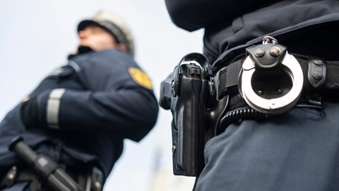 Symbolbild: Ein Polizist und eine Polizistin der Polizei Baden-Württemberg stehen in einem Industriegebiet.