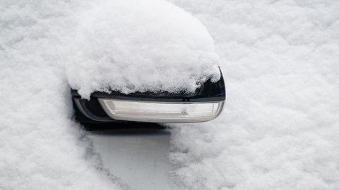 Der Außenspiegel eines Autos ist mit Schnee bedeckt. Am Samstag rechnet der DWD mit Schnee in weiten Teilen von Baden-Württemberg.