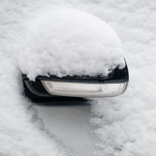 Der Außenspiegel eines Autos ist mit Schnee bedeckt. Am Samstag rechnet der DWD mit Schnee in weiten Teilen von Baden-Württemberg.