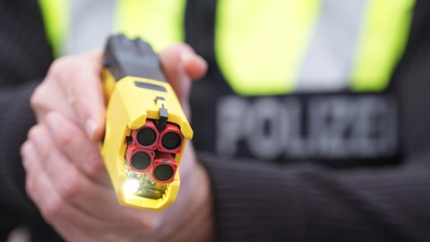 Ein Polizist hält einen Taser in den Händen. Beieinigen Einheiten der Streifenpolizei in BW wird der Einsatz von Tasern getestet.