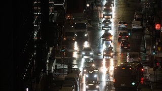 Autofahrer in Stuttgart fahren über eine nasse Straße.