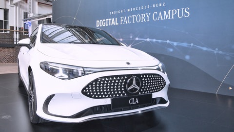 Rückrufaktion: Der neue Mercedes CLA steht vor einem Plakat.