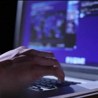 Person tippt am Laptop