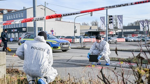 Mitarbeiter der Spurensicherung der Polizei arbeiten an einem Tatort. 