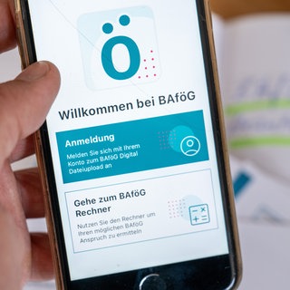Eine App zur Bafög Beantragung ist auf einem Mobiltelefon zu sehen. Laut BAföG-Portal ist die Webseite wegen Wartungsarbeiten bis ca. 26.01.2026 offline