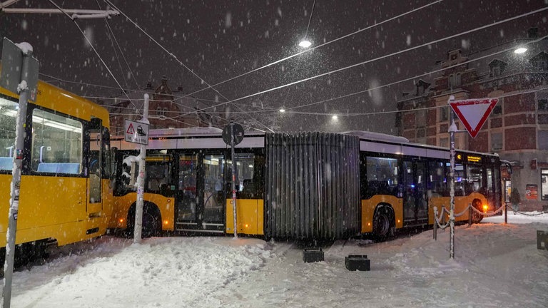 Ein Linienbus ist bei Schneeglätte in Stuttgart von der Fahrbahn gerutscht und versperrt einer Straßenbahn die Weiterfahrt.