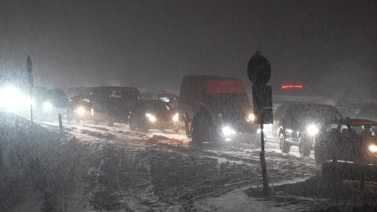 Autos und Lastwagen stehen auf der Autobahn 8 zwischen Kirchheim Teck-Ost (Kreis Esslingen) und Mühlhausen (Rhein-Neckar-Kreis). Wegen heftigen Schneefalls bildete sich ein langer Stau.