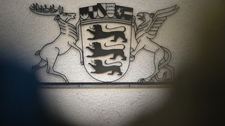 Das Wappen Baden-Württembergs in einem Saal des Landgerichts Stuttgart. Der ehemalige baden-württembergische Polizeiinspekteur muss wieder vor Gericht.