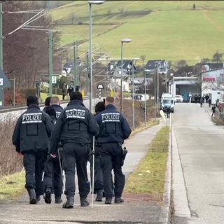 Eine Gruppe von Polizisten läuft entlang einer Straße