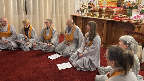 Die Teilnehmenden tragen bei der Morgenpraxis der "Yun-Hwa"- Gemeinschaft in der Nähe von Stuttgart graue Roben