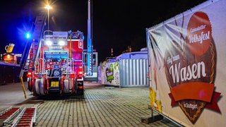 Ein Feuerwehrauto steht mit Blaulicht auf dem Gelände des Cannstatter Wasen.