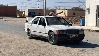 Ein gebrauchter Daimler steht auf einer Straße in Algerien. Hier glaubt man noch an den Mercedes-Stern.