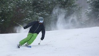 Ein Skifahrer ist in einem Skigebiet in Baden-Württemberg auf der Piste unterwegs (Archivbild). Der Schnee am Wochenende reicht wohl nur in den Höhenlagen für Wintersport.