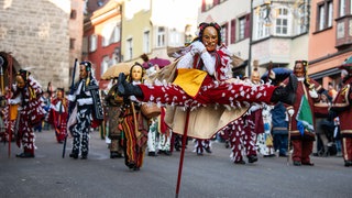 Ein Federahannes, eine Rottweiler Narrenfigur, springt während des Narrensprungs in Rottweil am Rosenmontag.