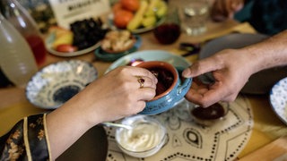 Zwei Gläubige essen am ersten Tag des Ramadan gemeinsam Iftar (Archivbild). 2026 beginnt der Ramadan fast zeitgleich mit der christlichen Fastenzeit.