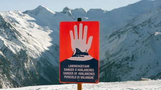 Ein Schild warnt in einem Skigebiet in den Alpen vor Lawinengefahr (Archivbild)