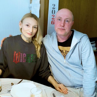 Serhii und Nataliia Shkola sitzen gemeinsam an einem Tisch.