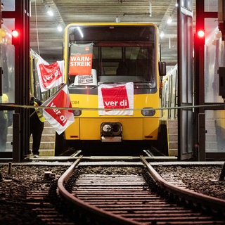 Streikende der Stuttgarter Straßenbahnen AG (SSB) gehen am frühen Morgen zu einem Straßenbahn-Depot.