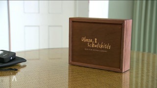 Ein feingearbeitetes Holzkästchen enthält den Computerstick mit dem Erinnerungsvideo.