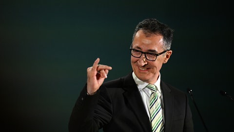 Cem Özdemir (Grüne), Spitzenkandidat Landtagswahl Baden-Württemberg, macht bei der Wahlparty seiner Partei eine Geste und reckt den kleinen Finger der rechten Hand hoch.