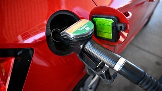 Ein Auto wird mit einer Zapfpistole an einer Tankstelle betankt.