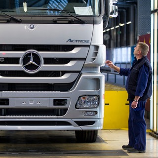 Mitarbeiter überprüfen in Wörth im Werk von Mercedes Benz einen Lastkraftwagen. 