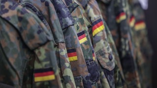 Feldjacken der Bundeswehr hängen auf einer Kleiderstange.