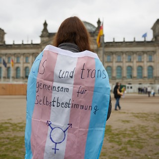 Eine Teilnehmerin steht bei einem Protest vor dem Bundestag. Dieser hat 2024 das Selbstbestimmungsgesetz beschlossen. Jetzt sehen viele trans Personen eine Meldeverordnung als Rückschritt im Kampf um Selbstbestimmung. (Symbolfoto)