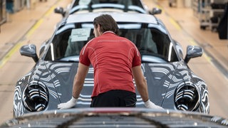 Ein Porsche-Mitarbeiter in der Produktion. Porsche hat im ersten Quartal 2026 weltweit 15 Prozent weniger Fahrzeuge verkauft. 