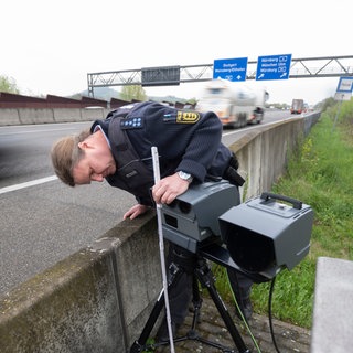 Eine mobile Geschwindigkeitsmessanlage der Autobahnpolizei Weinsberg wird am Rand der A6 von einem Polizeibeamten eingerichtet. Am Mittwoch ist in Baden-Württemberg Höhepunkt des "Blitzermarathons"