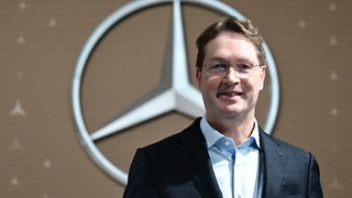 Ola Källenius, Vorstandsvorsitzender der Mercedes-Benz Group AG, steht vor der Bilanz Pressekonferenz vor einem Mercedes-Benz Markenlogo. Bei der Hauptversammlung im April forderten Aktionäre Tempo und einen Plan für das schwächelnde Geschäft in China. Källenius will zehn Prozent mehr Autos verkaufen als 2025.