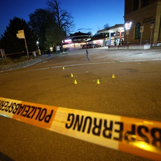 Absperrband hängt am Bahnhof Marbach am Neckar (Kreis Ludwigsburg). Die Polizei sichert nach Schüssen, bei denen zwei Menschen verletzt wurden, Spuren.
