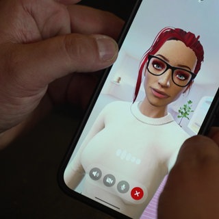 Auf einem Handy-Display ist eine virtuelle Frau mit roten Haaren in einem weißen Oberteil zu sehen.