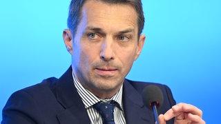Martin Rothweiler, Vorsitzender der AfD-Landtagsfraktion Baden-Württemberg, spricht vor einem blauen Hintergrund bei einer Pressekonferenz des Fraktionsvorstands der AfD-Fraktion im Landtag von Baden-Württemberg. Er trägt einen dunkelblauen Anzug.