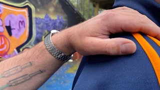 Mann legt anderem Mann Hand auf die Schulter