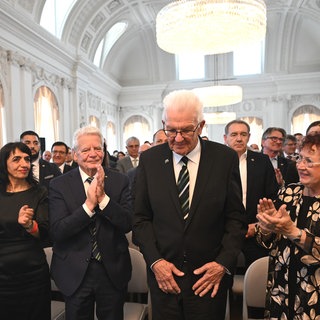 Winnfried Kretschmann bedankt sich bei den applaudierenden Gästen während des Festakts zu seiner Verabschiedung.
