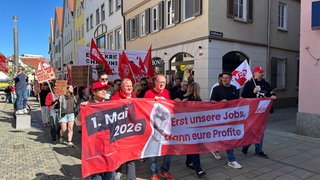 Teilnehmer einer Demonstration zum 1. Mai in Reutlingen tragen ein Banner mit der Aufschrift "Erst unsere Jobs, dann eure Profite".