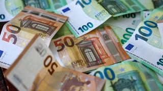 Geldscheine auf einem Tisch. Laut BW-Finanzministerium werden Kommunen in den nächsten drei Jahren insgesamt fast drei Milliarden Euro weniger einnehmen werden als geplant.