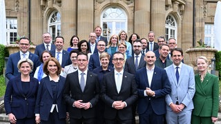 Ministerpräsident von Baden-Württemberg Cem (Grünen) und Manuel Hagel (CDU) stehen nach der Vereidigung der neuen Landesregierung mit den Ministern und den Staatssekretären vor der Villa Reitzenstein, dem Amtssitz des Ministerpräsidenten.