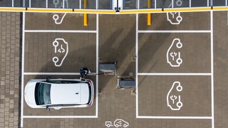 Ein E-Auto lädt auf einem Parkplatz: Viele Menschen, die ihren Stromer oder Plug-in-Hybrid 2026 gekauft haben, bekommen dafür eine Prämie