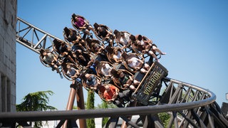 Ein Wagen der Achterbahn Voltron fährt vollbesetzt durch eine Kurve. Bei der neuen Attraktion des Europa-Parks können die Wartezeiten bei hohem Besucheraufkommen lang sein.
