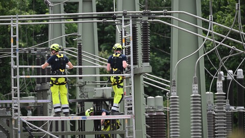 Mitarbeiter von FairNetz arbeiten auf dem Gelände eines Umspannwerks, in dem es in der Nacht gebrannt hatte.
