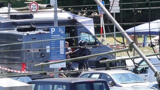 Polizisten in Schutzanzügen sind am Einsatzort. Nach einer Bombendrohung sind ein 24-Stunden-Flohmarkt und der Bahnhof in Konstanz teilweise gesperrt.