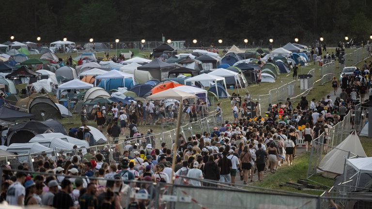 Zahlreiche Festivalbesucher verlassen beim Auftakt des Southside-Festivals das Festivalgelände. Aufgrund des Wetters wurde das Gelände evakuiert.