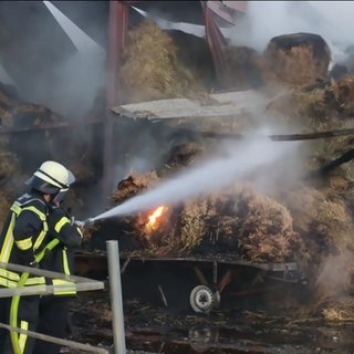 Eine Person der Feuerwehr löscht einen Brand